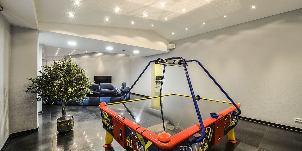 Elegante einfache weisse Deckengestaltung mit individuellem Beleuchtungskonzept im privaten Hobbyraum